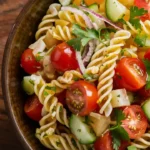 A vibrant pasta salad with a balance of colorful vegetables, herbs, and dressing.